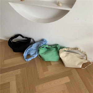 Dettaglio delle borse a secchiello in nylon con manici arricciati in quattro colori