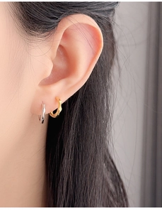 Detailed view of gold and silver S925 sterling silver hoop earrings with wavy texture