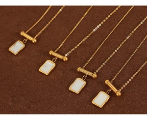Detailed close-up of 18K gold plated sugar cube shell pendants on necklaces