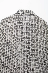Macro shot of geometric print chiffon blouse showing back collar and fabric texture