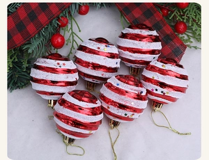 Close-up of red and white striped Christmas ornaments with snow texture and sequins