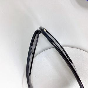 Détail macro de la charnière noire avec logo pique doré sur lunettes de soleil enfant