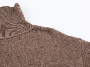 Détail du col roulé en maille côtelée douce sur un pull marron pour femme