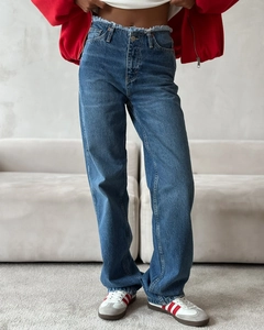 Detailed view of high-waist straight leg blue jeans with frayed waistband and denim texture