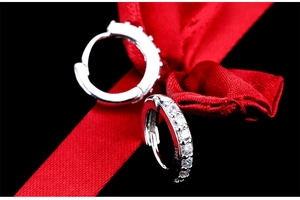 Macro shot of S925 sterling silver stamp on crystal hoop earrings with red ribbon bow