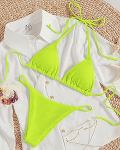 Flat lay of neon green ribbed halter bikini with starfish and summer beach accessories