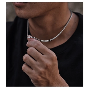 Close-up of silver braided titanium steel necklace worn on neck in natural light