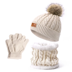 Detail des Zopfstrick-Wintersets mit warmem Fleecefutter und flauschigem Kunstfell-Pompon