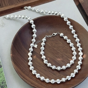 S925 sterling silver cat eye bead necklace and bracelet set on a wooden tray
