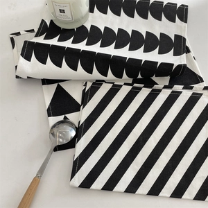 Detail of minimalist black and white geometric placemats with neat stitched edge finishing