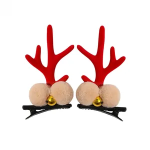 Detail of Christmas reindeer antler hair clips with plush pom-poms and golden bells