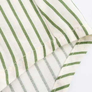 Gros plan sur la texture du tissu à rayures vertes et blanches et l'ourlet roulé