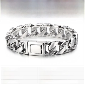 Detailed view of stainless steel Cuban link bracelet with engraved Greek meander pattern