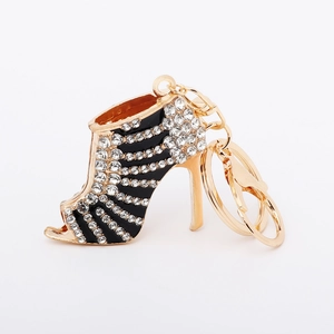 Detail of high heel keychain with black enamel stripes and shimmering white rhinestones