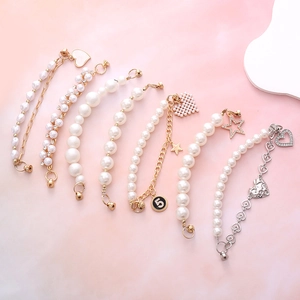 Set of seven pearl and metal phone wristbands with heart, star and number charms