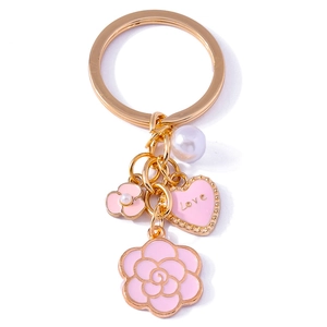 Golden keychain with pink camellia flower, love heart, and pearl bag charm accessory