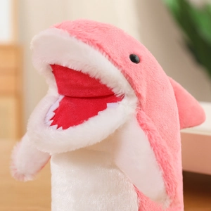 Close-up of pink plush shark puppet showing soft fabric texture and detailed white teeth