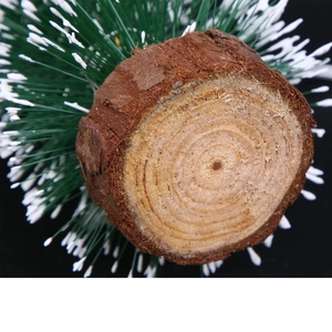 Macro detail of the natural log base with bark texture on a mini frosted Christmas tree
