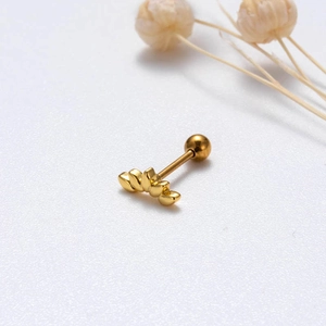 Macro shot of gold lotus flower cartilage earring with screw ball back detail
