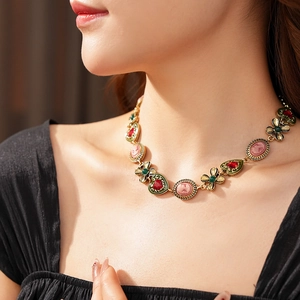 Gros plan d'un collier vintage doré avec camée rose et pierres précieuses en cœur