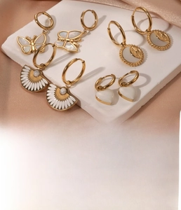 Detail of vintage gold titanium steel earrings with shell inlay in heart and butterfly shapes