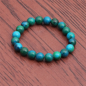 Macro shot of blue-green lapis lazuli beaded bracelet on a dark rustic wooden surface