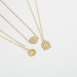Minimalist gold necklaces with Saint Benedict and Virgin Mary pendants on white leather