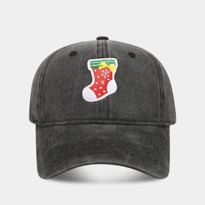 Close-up of a vintage black baseball cap featuring a detailed Christmas stocking embroidery