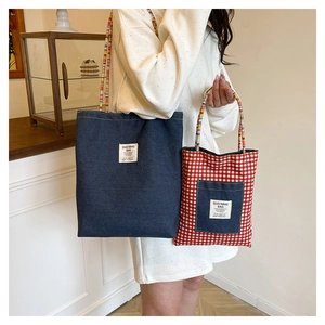Sacs cabas réversibles à carreaux et denim en deux tailles portés par un mannequin pro
