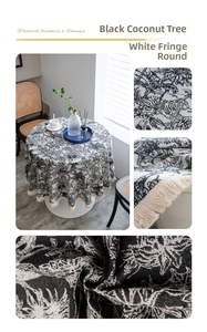 Detail of round jacquard tablecloth with black tropical patterns and white fringe edge