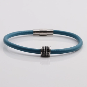Detail of blue leather cord bracelet featuring a micro-pave black zircon cylinder bead
