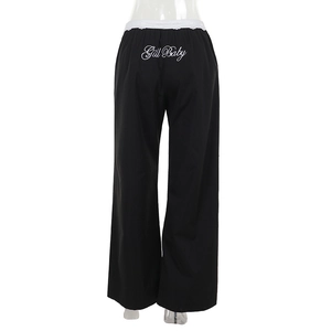 Vue détaillée du pantalon cargo noir à taille haute avec bordure en dentelle et broderie