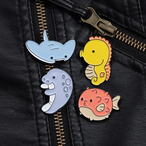 Set of 4 colorful ocean enamel pins including ray and seahorse on black leather jacket