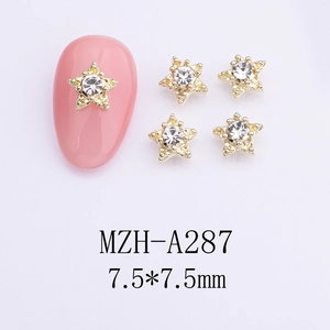 Detailed view of 7.5mm gold star nail charms with sparkling clear rhinestones