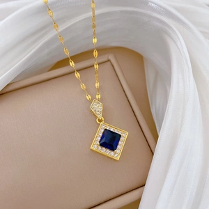 Detailed macro view of gold-plated necklace featuring a square blue sapphire pendant