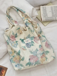 Off-white floral linen tote bag with watercolor prints on white bedding background