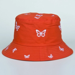 Close-up of white butterfly embroidery detail on a vibrant orange cotton bucket hat