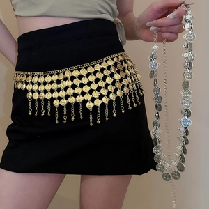 Detail of bohemian gold metal coin waist chain with tassels and embossed texture on black dress
