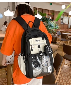 Detail view of the black and white backpack with a transparent front pocket and coin pouch