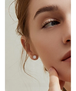 Macro shot of 925 sterling silver four-prong moissanite stud earring on ear