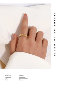 Detailed view of an 18K gold plated geometric ring with shell texture on model's finger