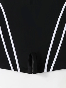Close-up of black plus size swimwear with white piping and durable split hem stitching