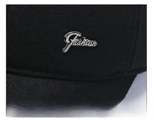 Detail of black winter wool cap featuring a silver metallic Fashion badge on side