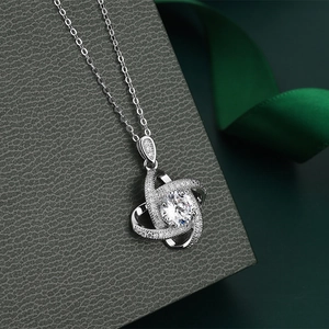 Macro view of clover necklace with central round zircon on a premium textured box