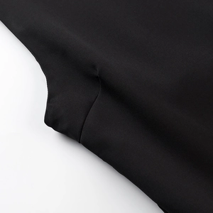 Detail of high-quality sewing stitches on a black backless dress with smooth fabric texture