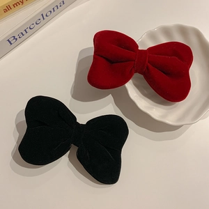 Detailed close-up of premium red and black velvet bow hair clips for girls