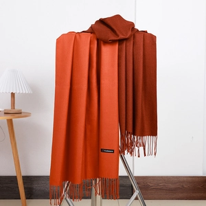 Detail of orange to dark brown gradient cashmere scarf with fringe and material tag