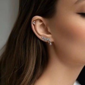 Macro detail of silver leaf ear climber and cuff set with sparkling zircon stones