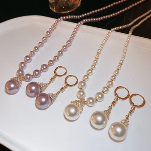 Vue détaillée des parures de bijoux en perles dorées avec perles violettes et blanches