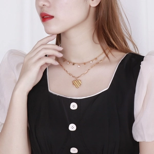 Collier double rang doré avec pendentif étoile et cœur texturé sur un mannequin